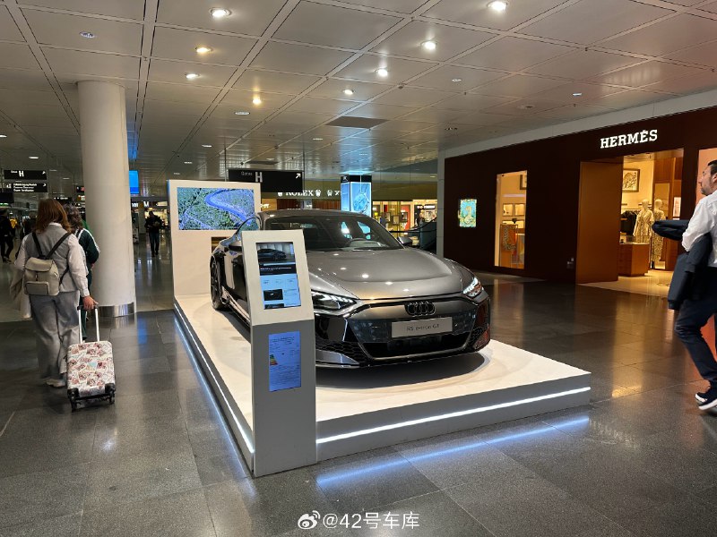 刚落地慕尼黑，机场候机楼里就出现了一台新款的奥迪 RS e-tron GT，新款属于中期改款车型，大灯、前杠、轮毂设计微调，但是在三电以及底盘上有比较大的提升，可惜无缘中国市场。配图