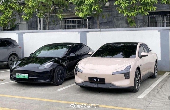 看到网上流传的这张小鹏 M03 和特斯拉 Model 3 停在一起的照片。两者在造型上都是偏圆润的造型，从视觉上看感觉 M03 会比 Model 3 整体稍微大一点。配图