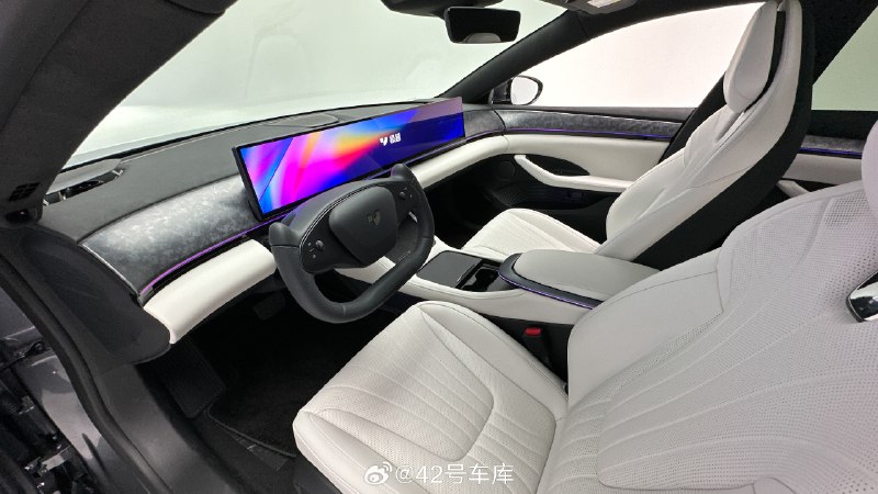 再来感受一下极越 07 的内饰设计，整体的内饰设计和极越 01 的差距并不大，中间还是一块 35.6 英寸的 mini LED 的屏幕，分辨率达到了 6K。边上大面积的饰板纹路，变成了类似于干碳的样式，还挺好看的。配图